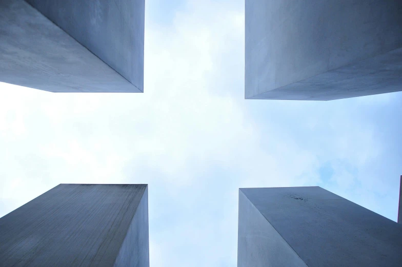 view looking up into the sky from between two cement structures