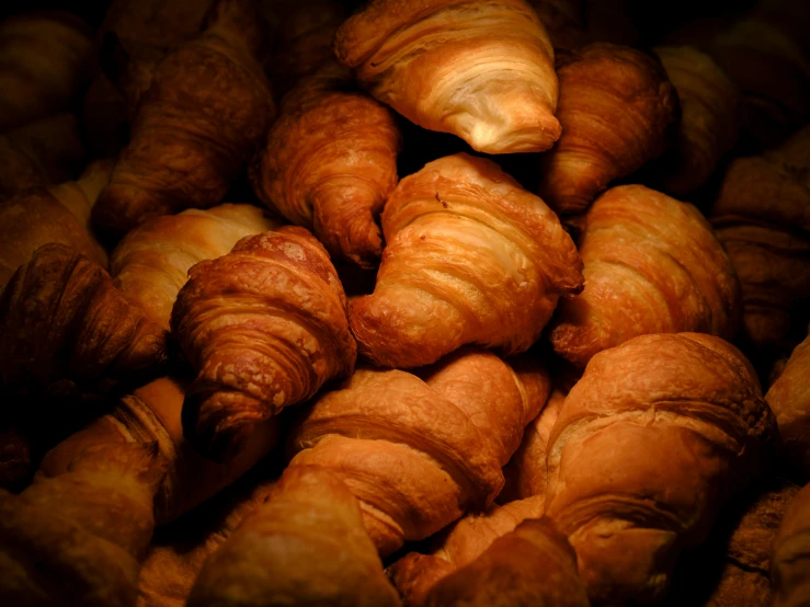 a pile of croissants that are covered in doughnuts