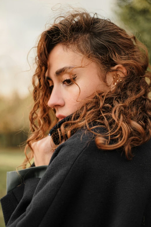 a beautiful young woman with curly hair in an urban setting