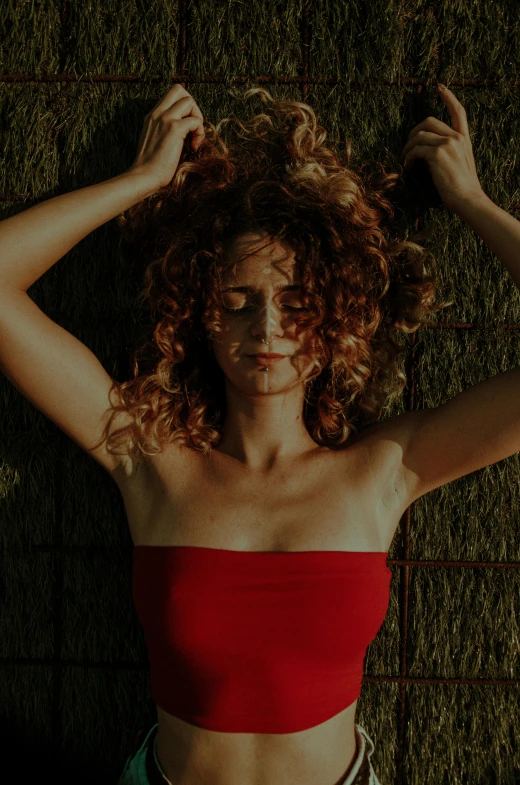 a woman with a very big  standing against a grass wall