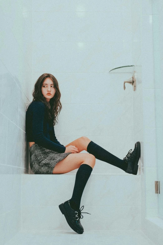 woman in black shoes and dress sitting on ledge