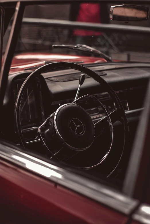 a old red car with dashboard showing the steering wheel