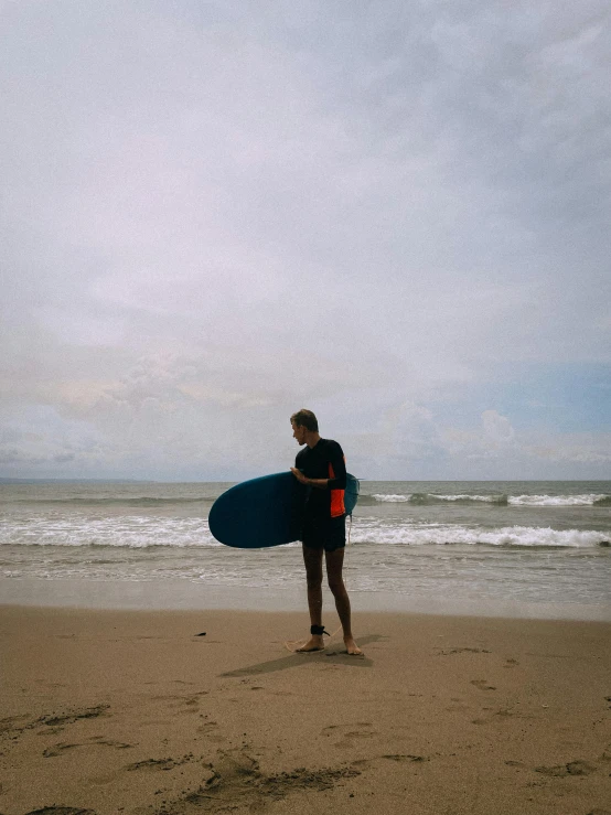 a person on a beach with a surf board