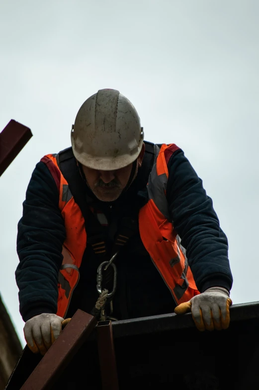 a man working on the side of a building on his hand