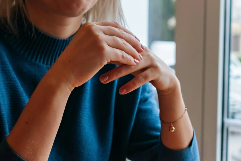 a woman is holding her wrist over her elbow