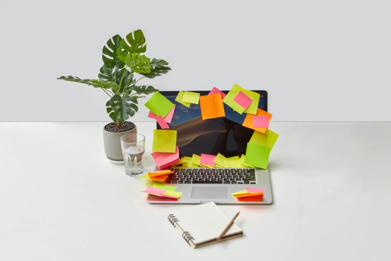 a lap top on a table covered with post it notes