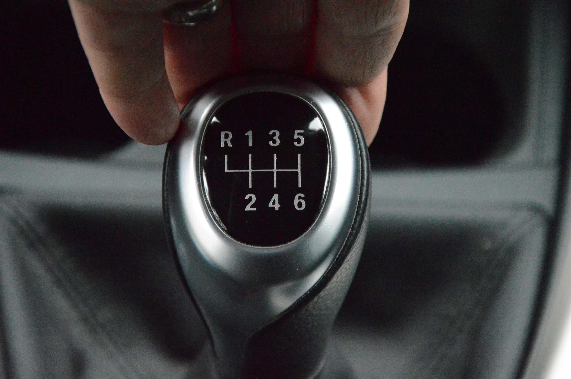 there is a hand holding a gear stick for a car