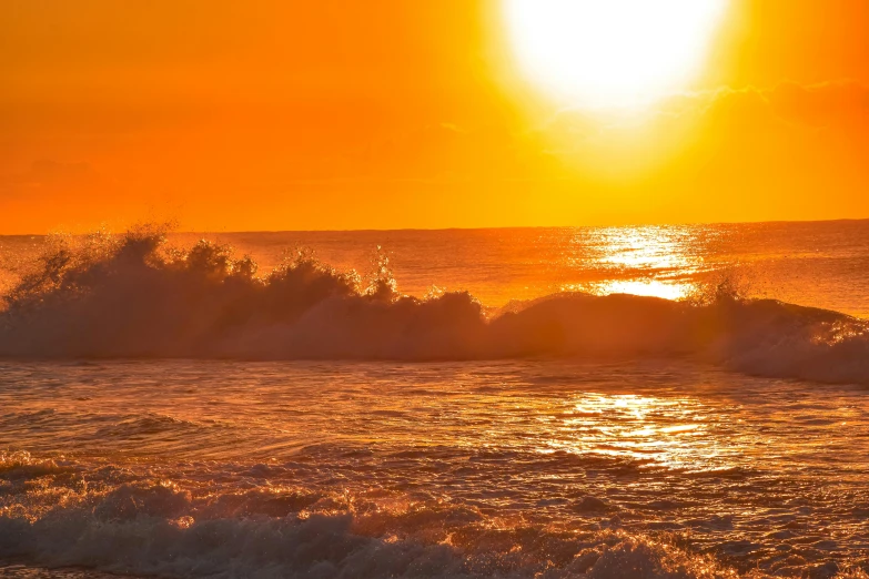 a surfboarder catches waves in the sunset