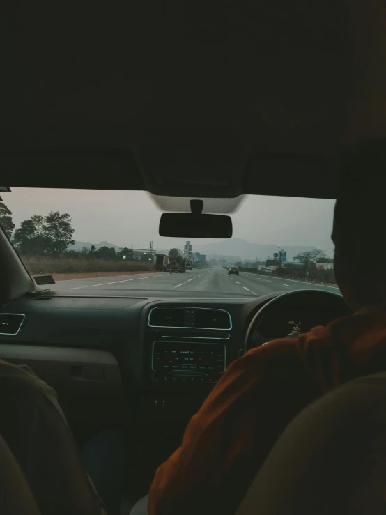 a man in his car watching the highway while driving