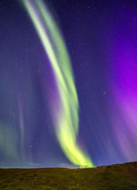 the northern lights as seen from a hill