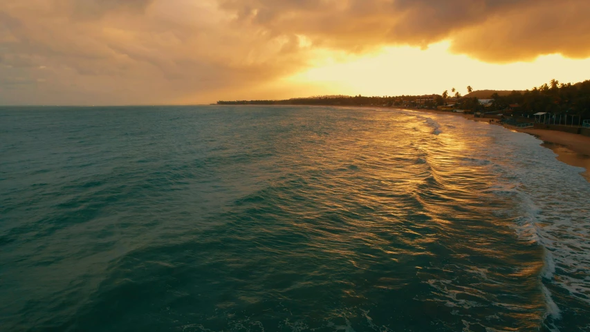 a picture of an ocean at sunset with dark clouds