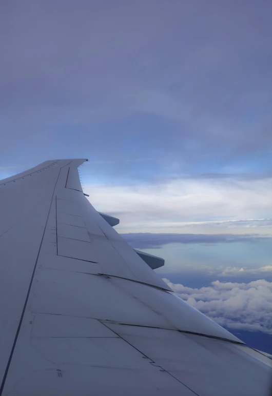 looking out the airplane window on a partly cloudy day