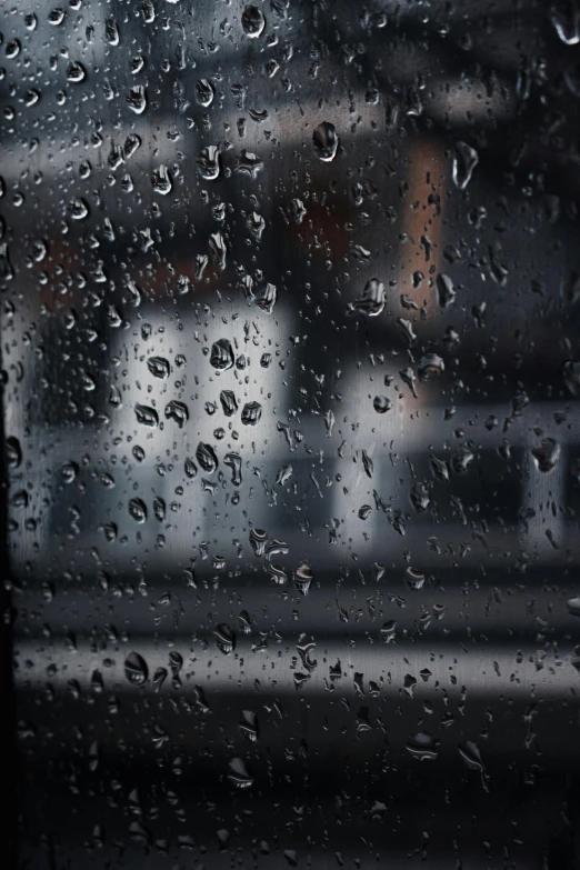 rain falling on a glass window with water droplets