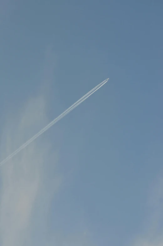 an airplane contrail is flying in the clear sky