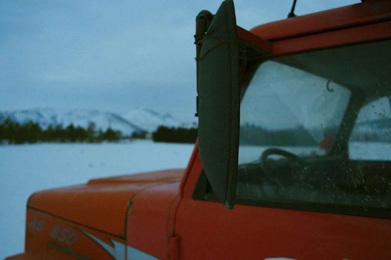 a red vehicle is parked in a snow covered field