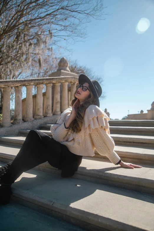 a woman in black pants and top sits on the steps