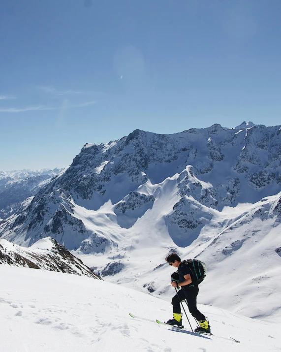 a man in ski gear on top of a snow covered mountain