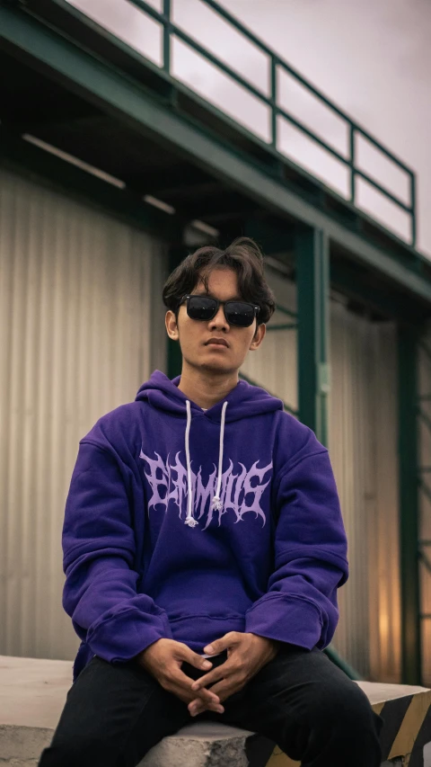 a man in purple sits on a wooden block