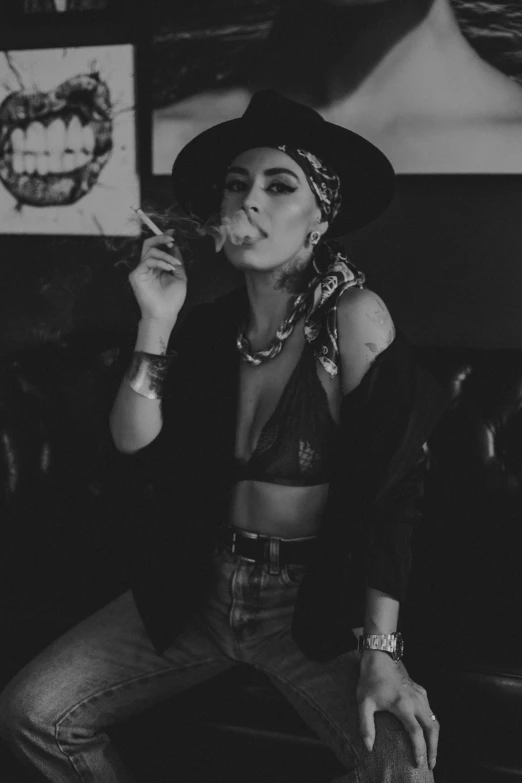 a woman smoking a cigarette in a black hat and dress