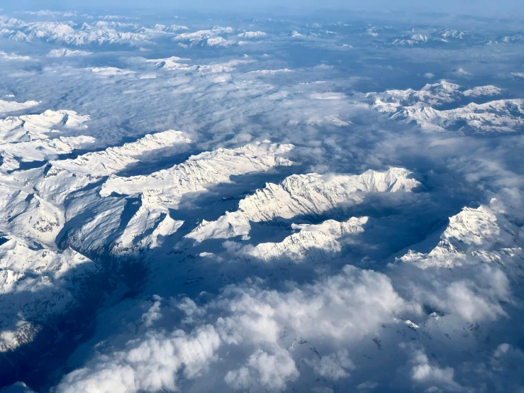 an air plane wing over mountains and clouds