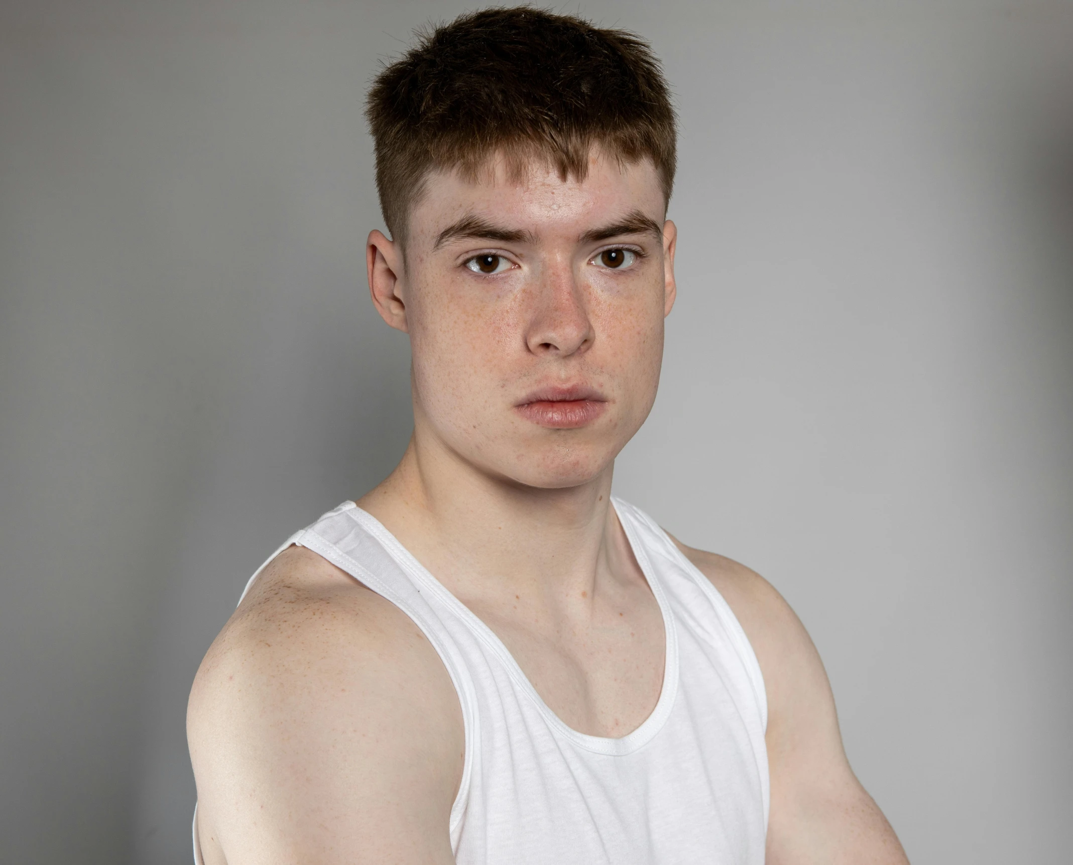 a man in white tank top posing for a picture