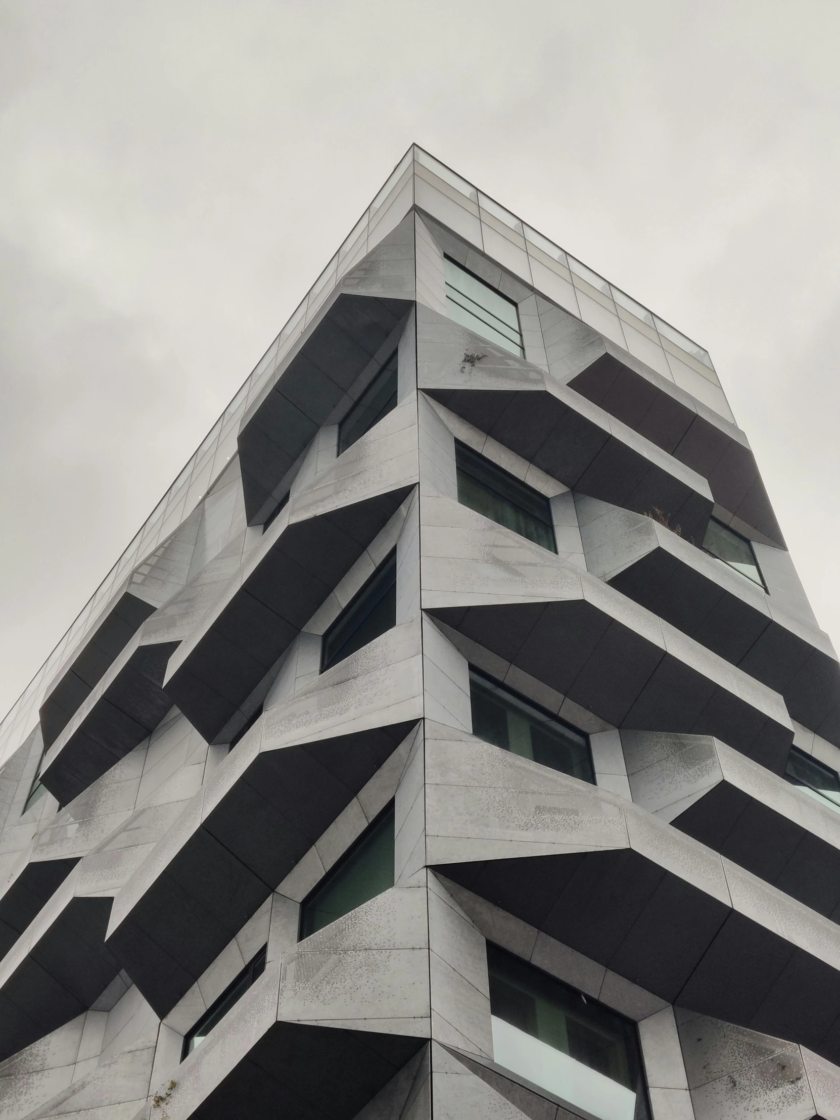 a tall building has black windows and white trim