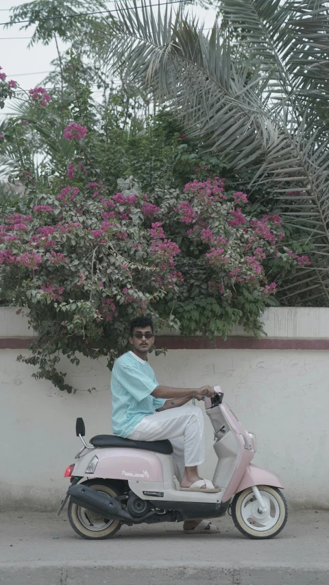 a person riding a pink motor scooter down a street