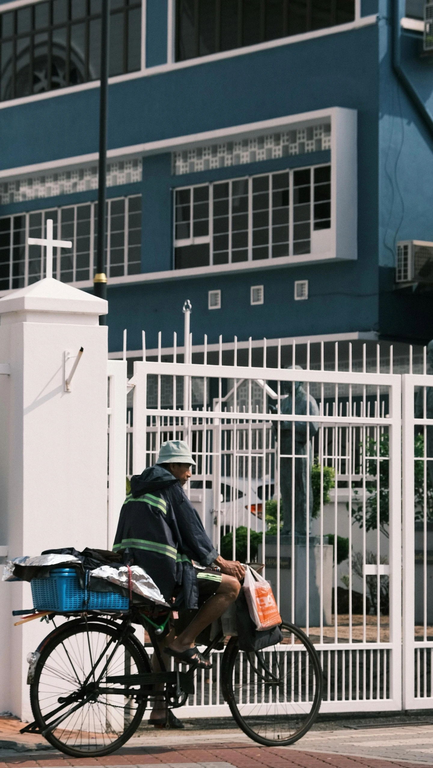 a man riding a bike next to a tall blue building