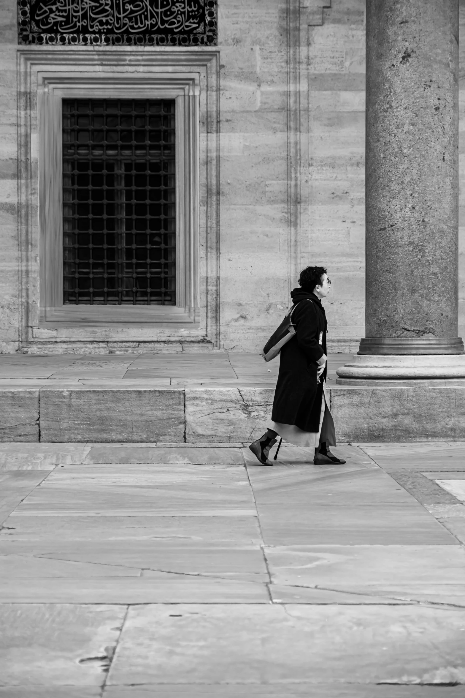 a black and white po of woman walking down a street