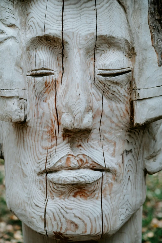 a sculpture made from wood with eyes closed