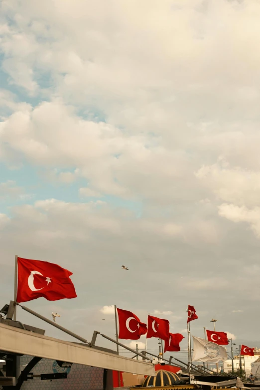 several flags blowing in the wind in the sky