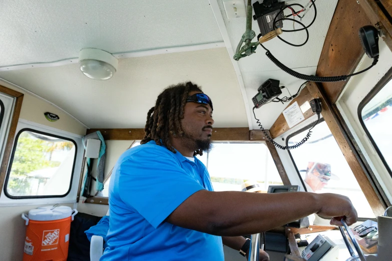 a man sits in the driver's compartment on a boat