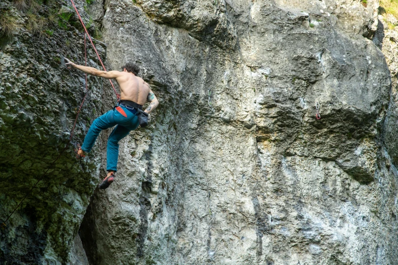 a man is climbing on the rock with his hands in the air