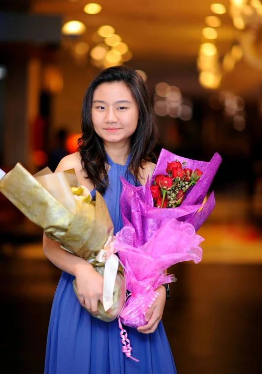 a woman holding a bunch of flowers and wrapping it in pink