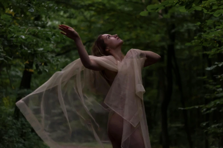 a woman in the woods with a scarf around her body