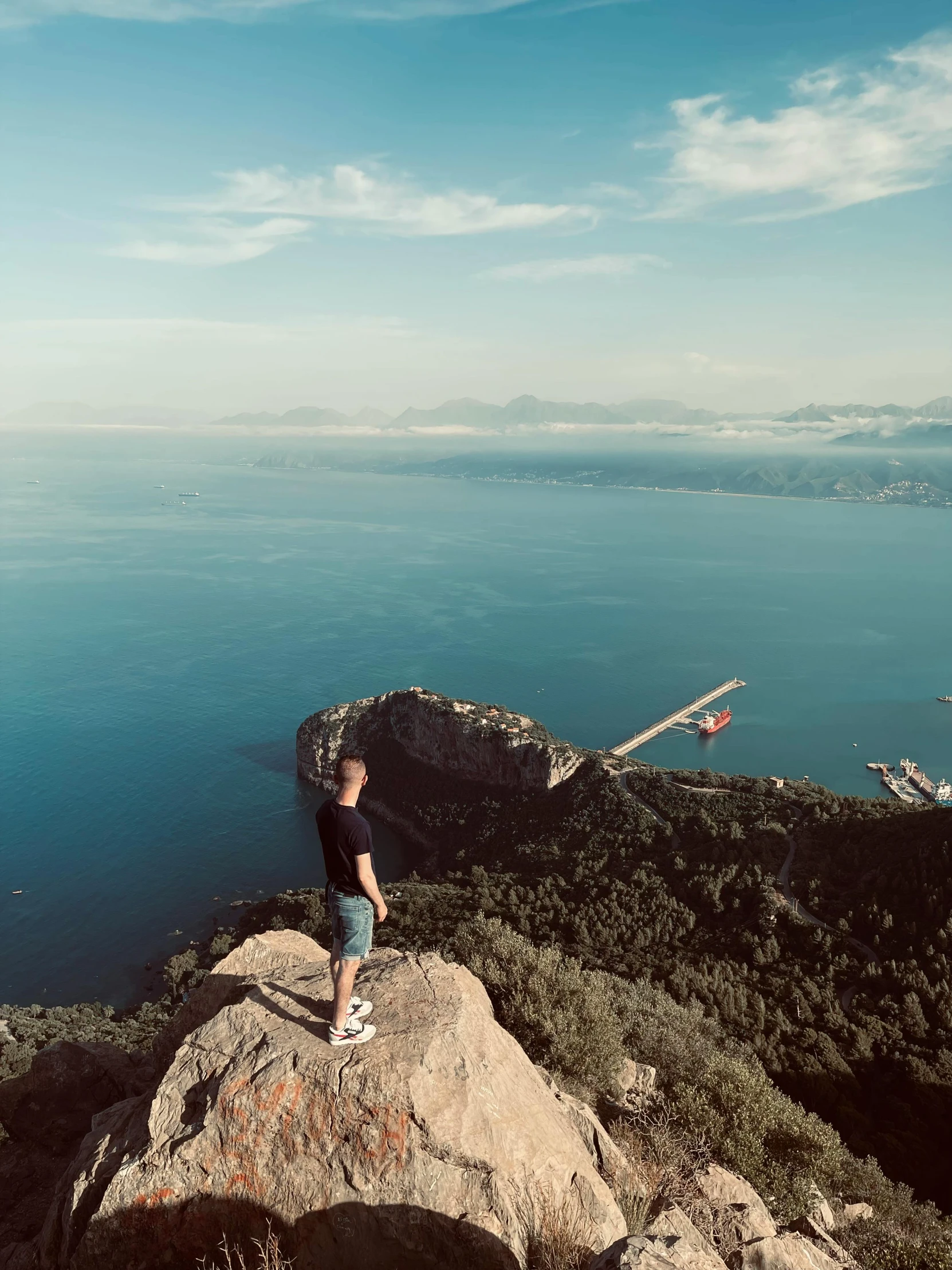 a man on a mountain overlooking the ocean