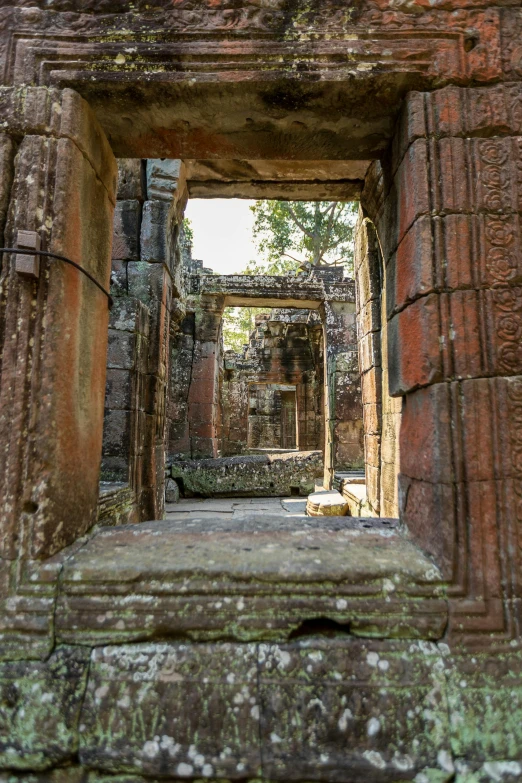 a doorway to the inner city of ruins with moss growing on it