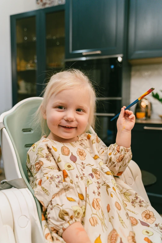 a child in an ironing chair is holding a pencil