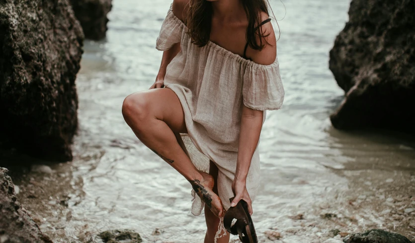 a  is standing near some rocks with her umbrella