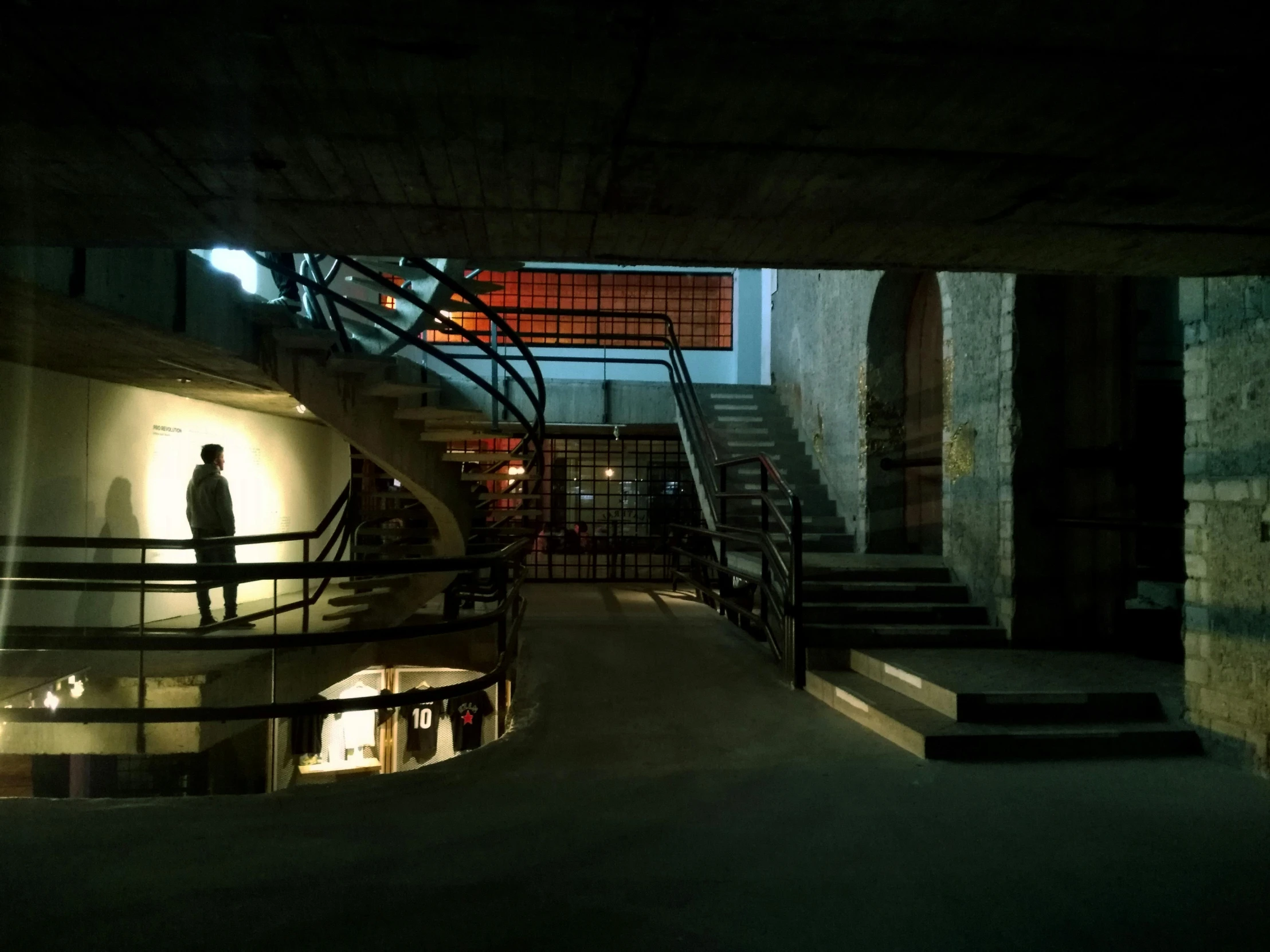 a man in a dimly lit room standing on stairs