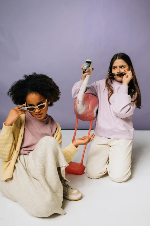 two girls with pink flamingos in their clothing posing