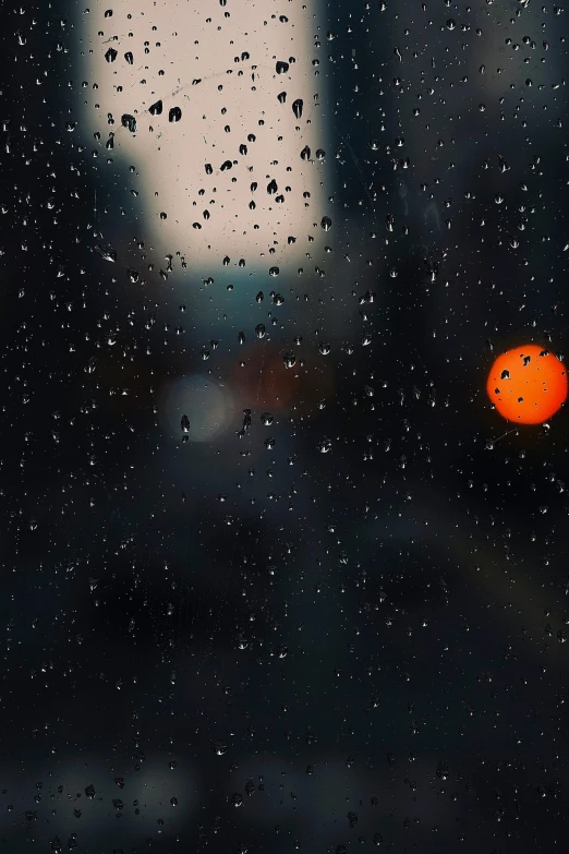 the orange is sitting on the window of a dark building