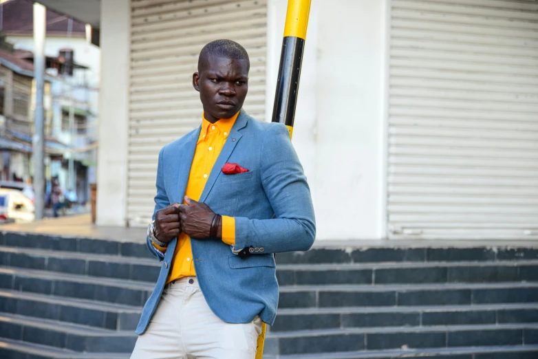 a black man holding a yellow bat near a building