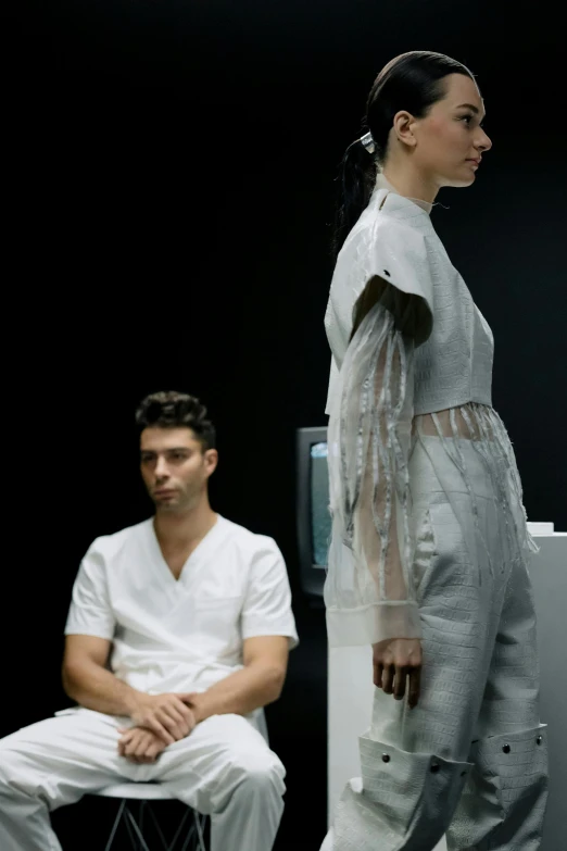 man watching woman wearing white outfit on runway