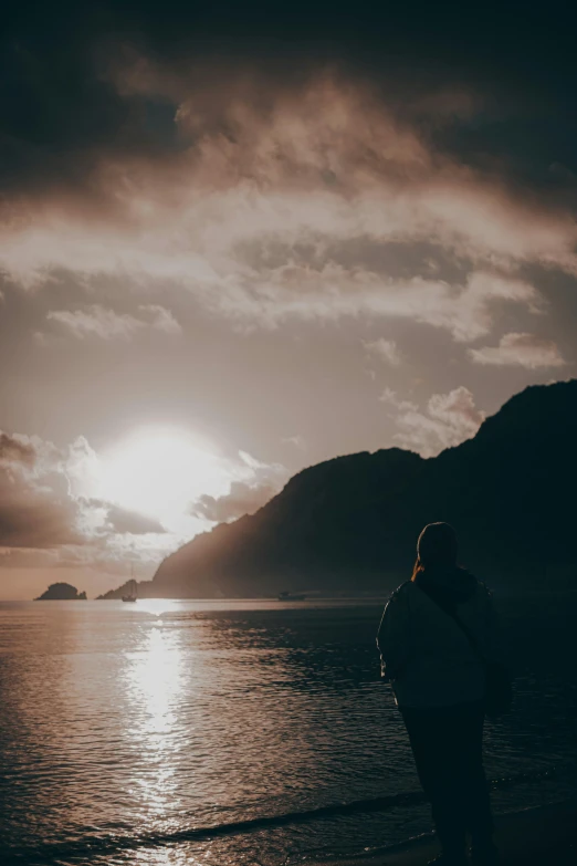 a person standing on the beach in front of the ocean