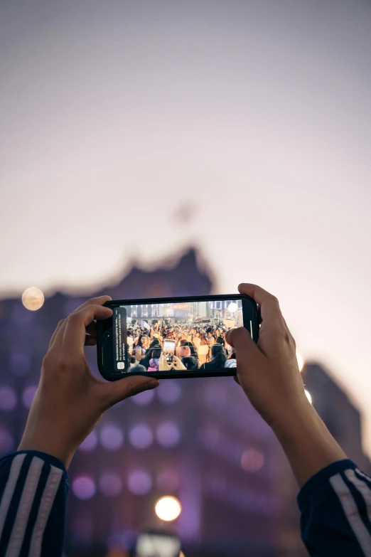 someone taking pictures with their cellphone of a crowd