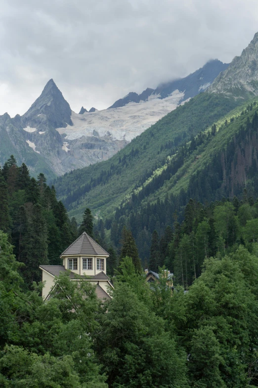 house on a mountain with green trees on either side