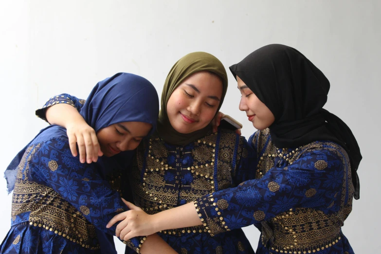 three women are smiling while wearing head coverings