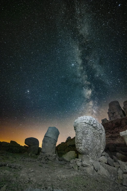 stars shine brightly in the sky above stones and boulders