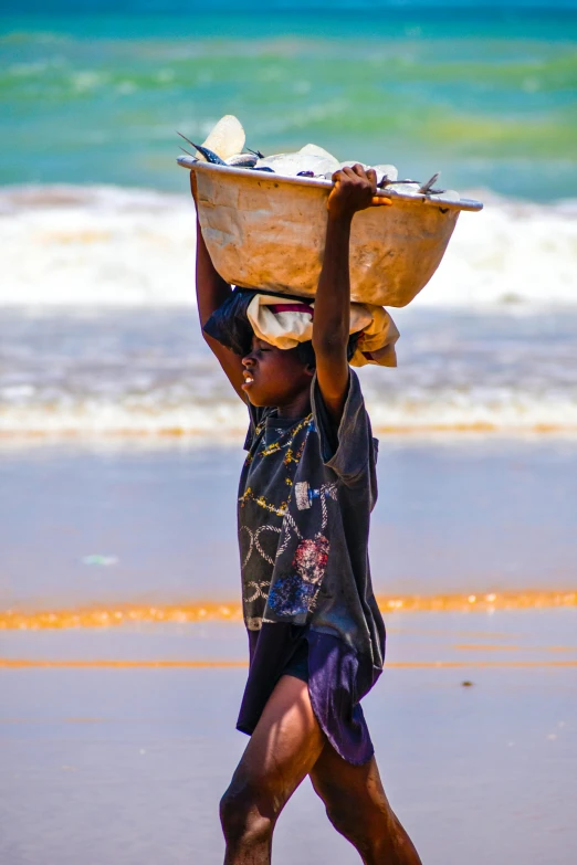 a young man is carrying soing on his head